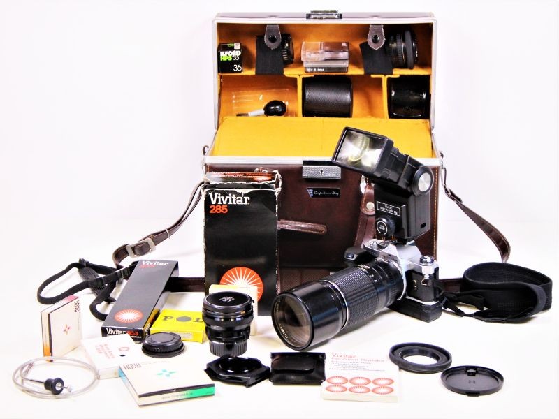 Pentax MX fotocamera met 4 lenzen, een flash, en andere accessoires